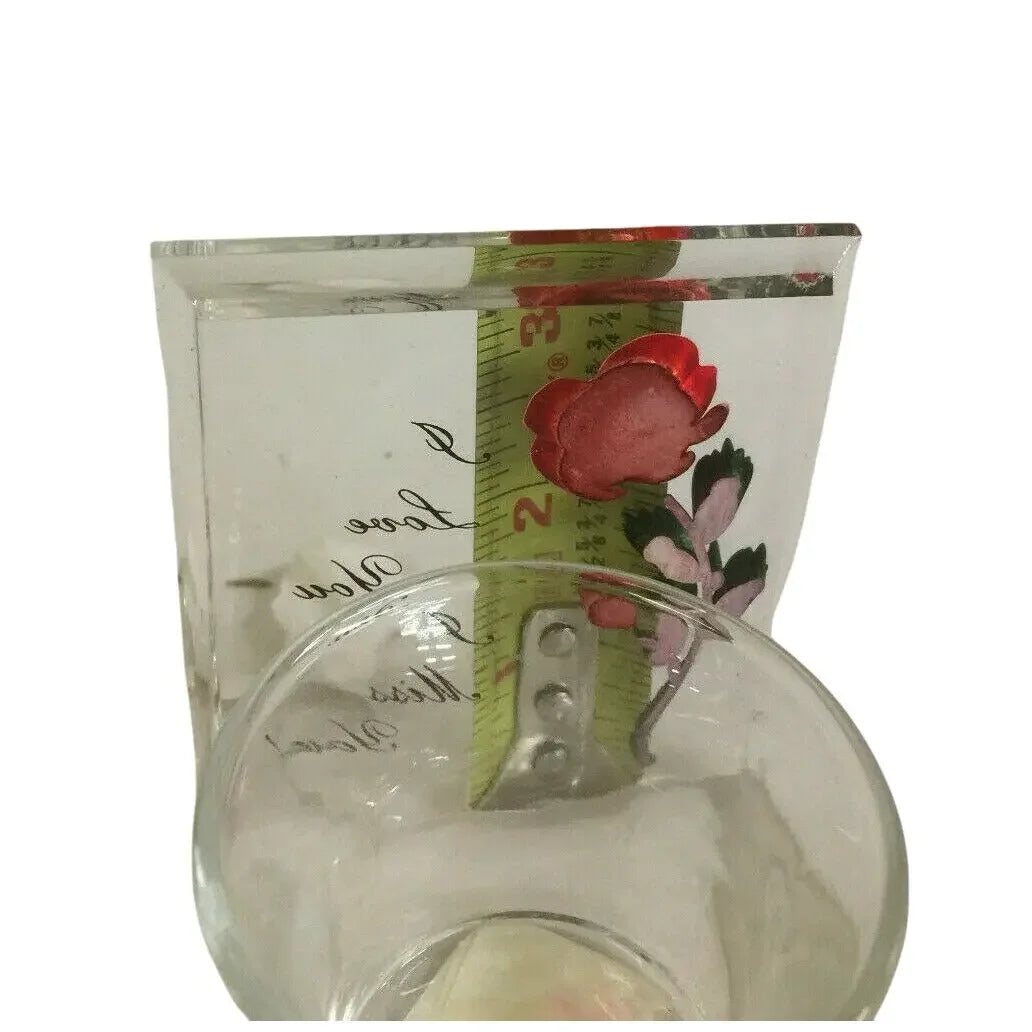 Clear resin block with red flower design and measuring tape beside a glass bowl