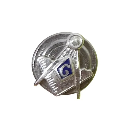 Silver lapel pin with compass and square symbol, blue G letter, circular background