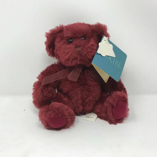 Plush maroon teddy bear with bow and tags, ideal soft toy gift against white background.