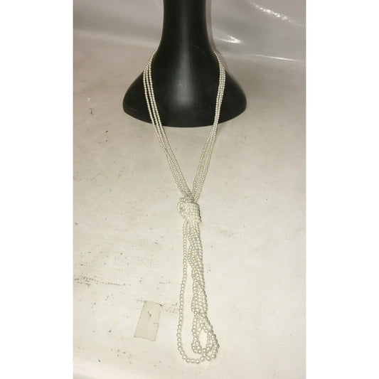 Long pearl beaded necklace with knot detail displayed on black jewelry bust