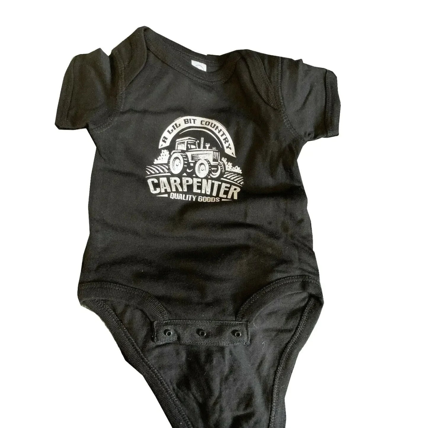 Black baby onesie with tractor and 'A Lil Bit Country Carpenter Quality Goods' text on front