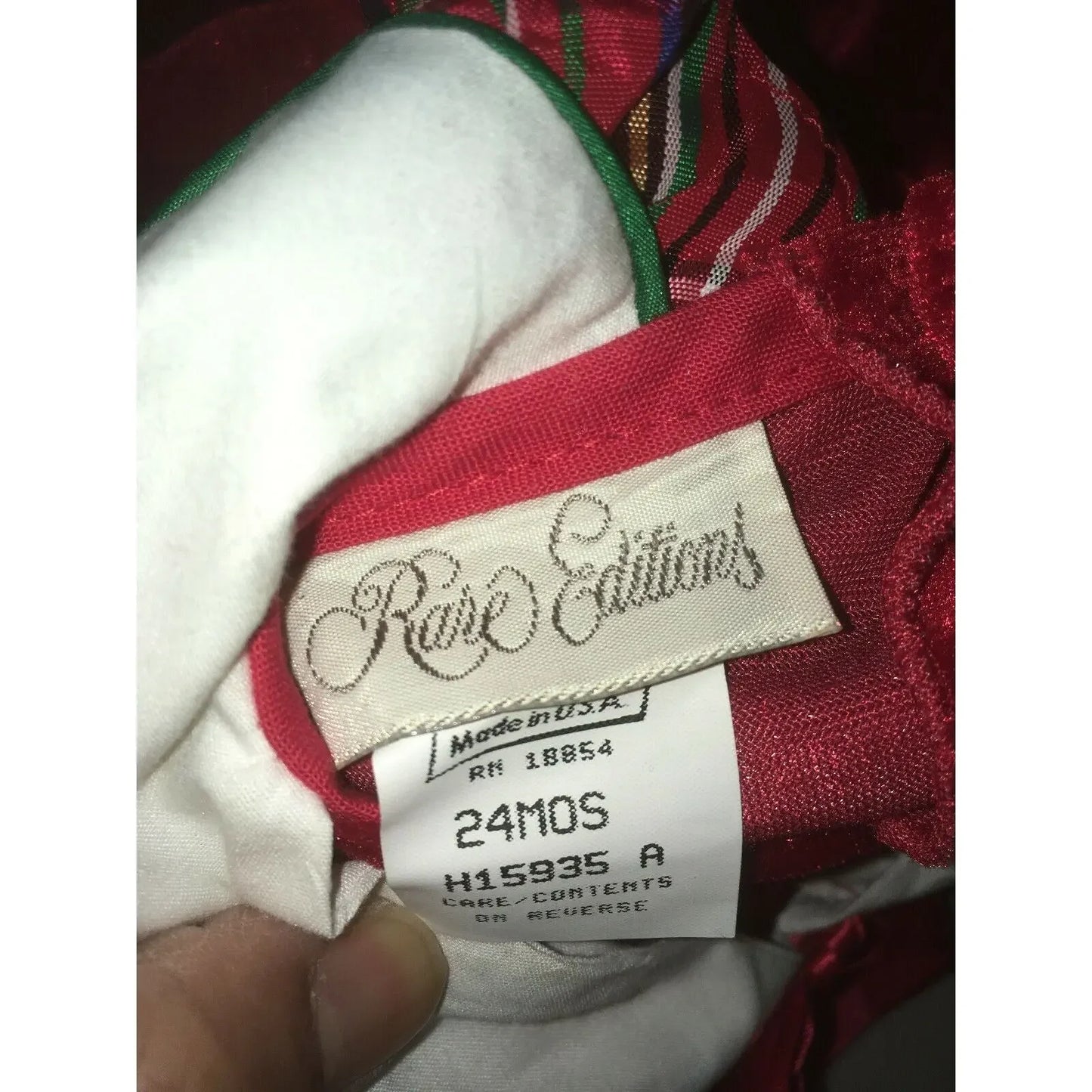 Rare Editions clothing tag showing size 24 months on red and white fabric garment.