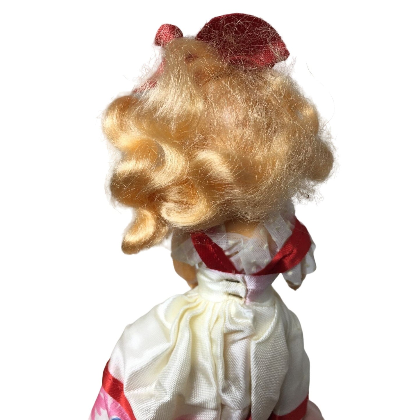 Vintage Collectible Doll With Blonde Hair wearing floral printed dress/red bow