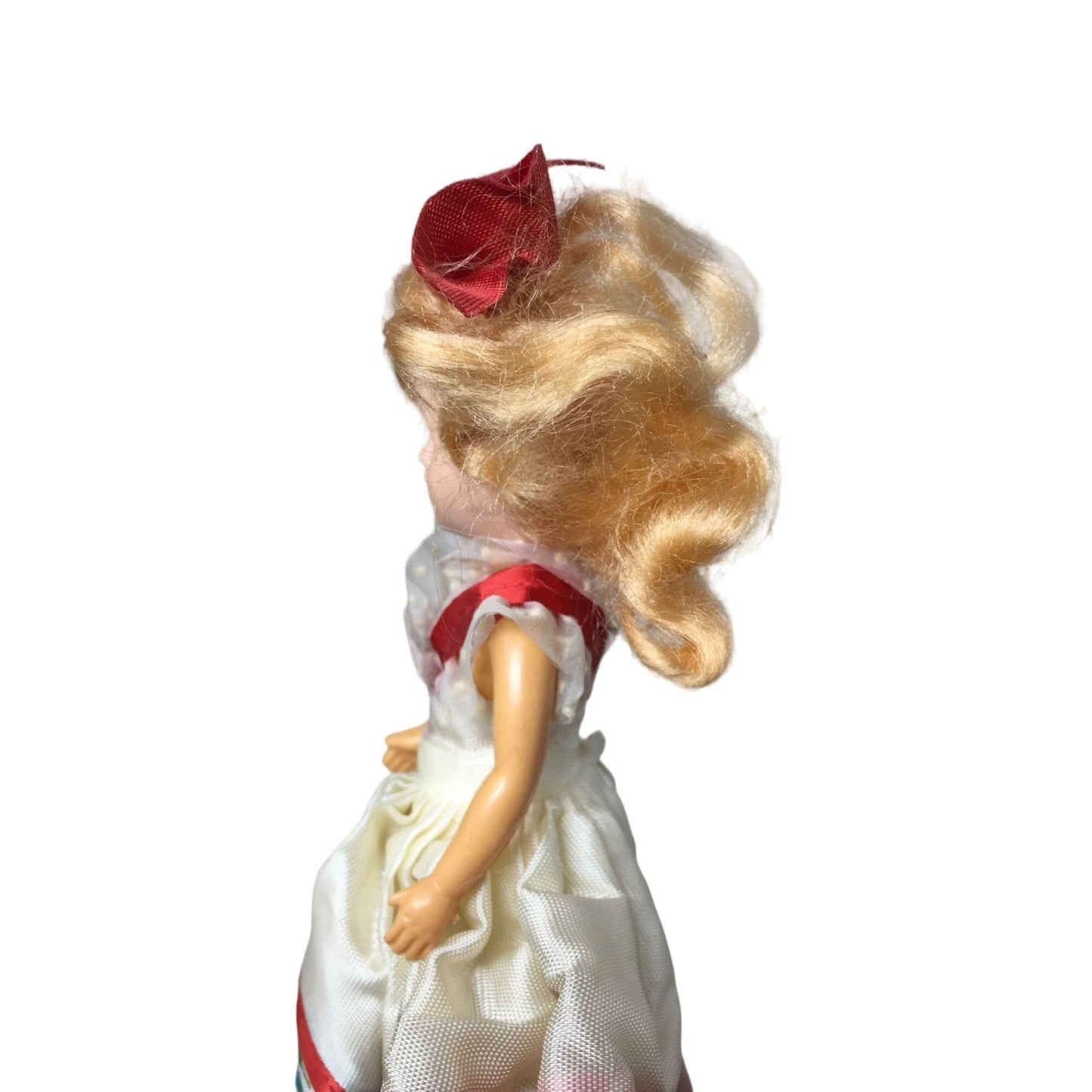 Vintage Collectible Doll With Blonde Hair wearing floral printed dress/red bow