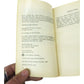 Close-up of a hand holding an open book, focus on copyright and publishing info page
