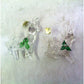 Clear glass reindeer ornaments with green holly leaves and red berries on a white background