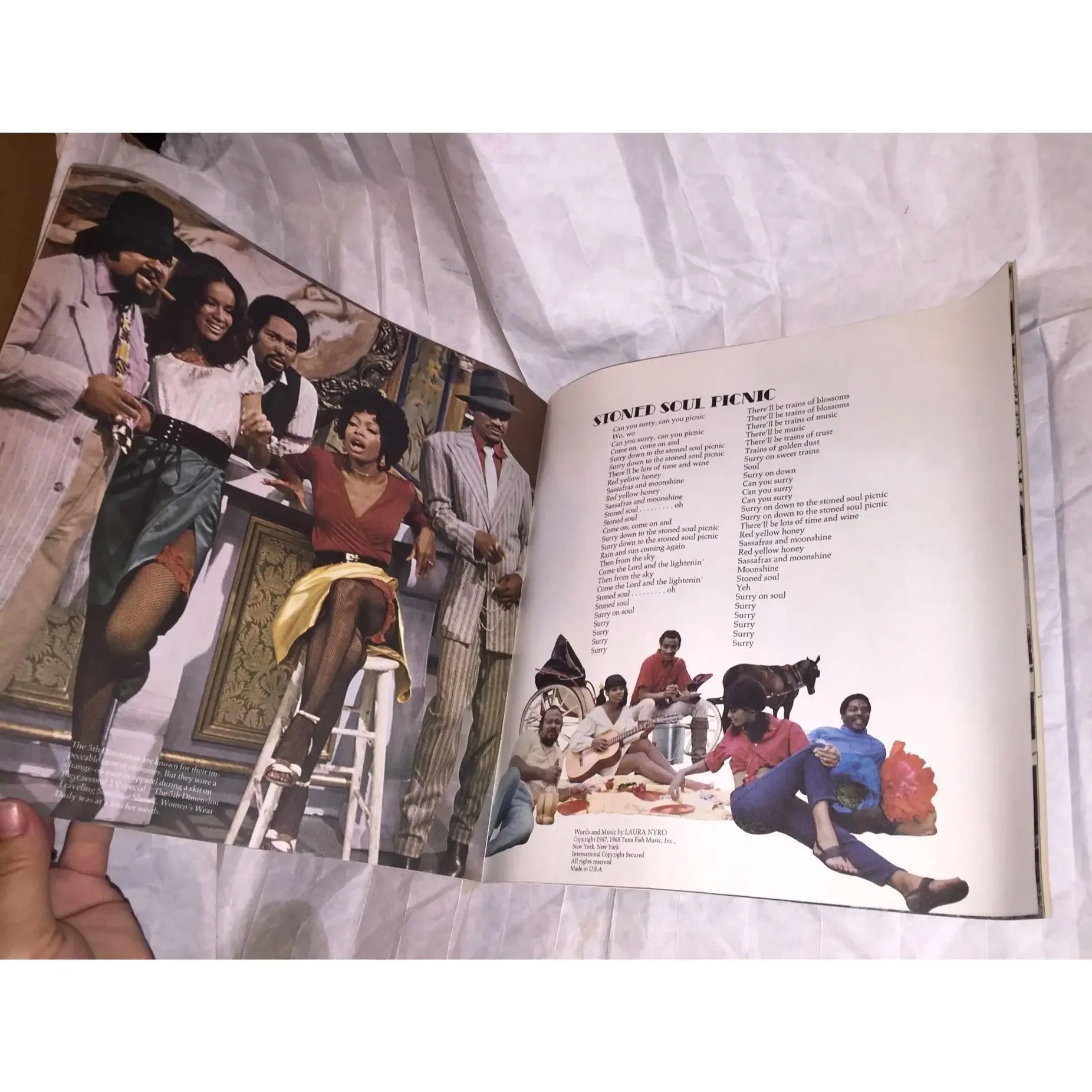 Open vintage vinyl record album booklet showing band photo and song lyrics on paper