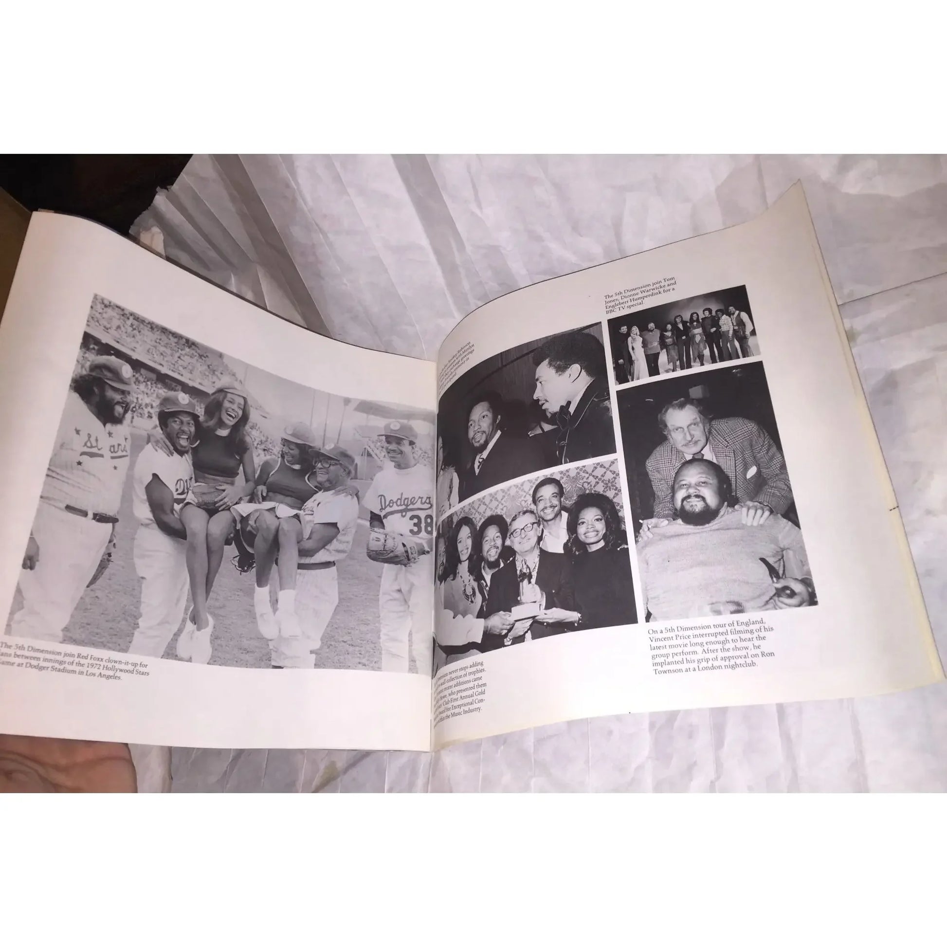 Open book showing black and white photos of baseball players, group portraits, and celebrities.