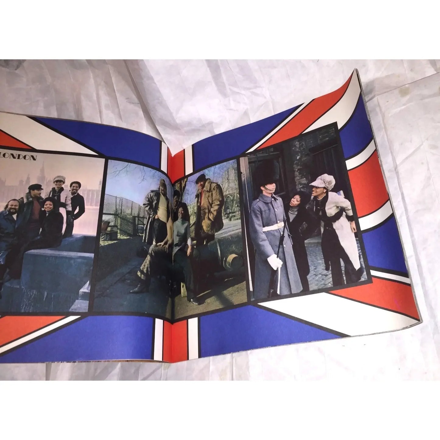 Vintage magazine open to pages with diverse people and London scenes, Union Jack border