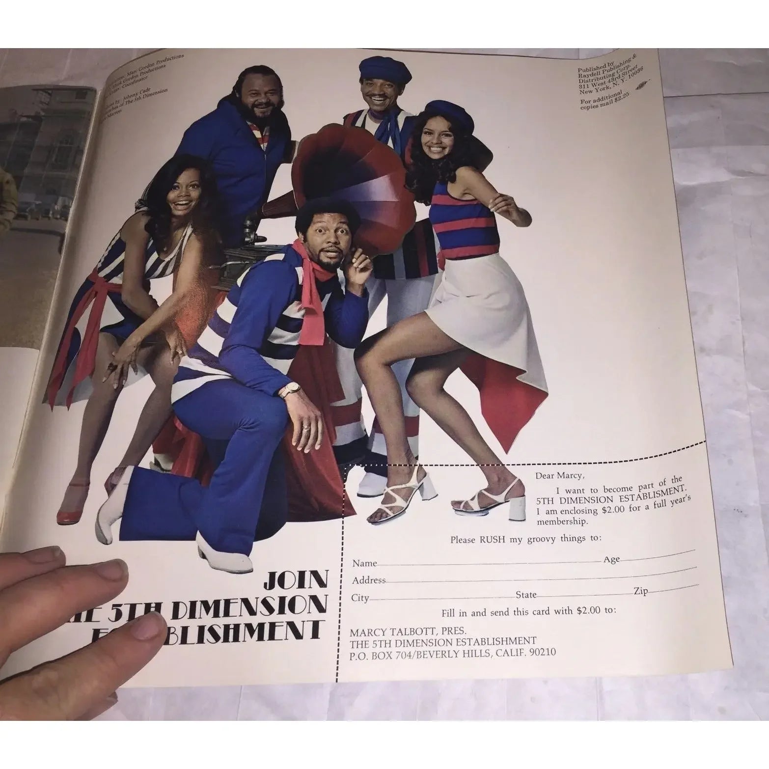 Vintage magazine ad with five adults in colorful retro outfits posing by a record player.