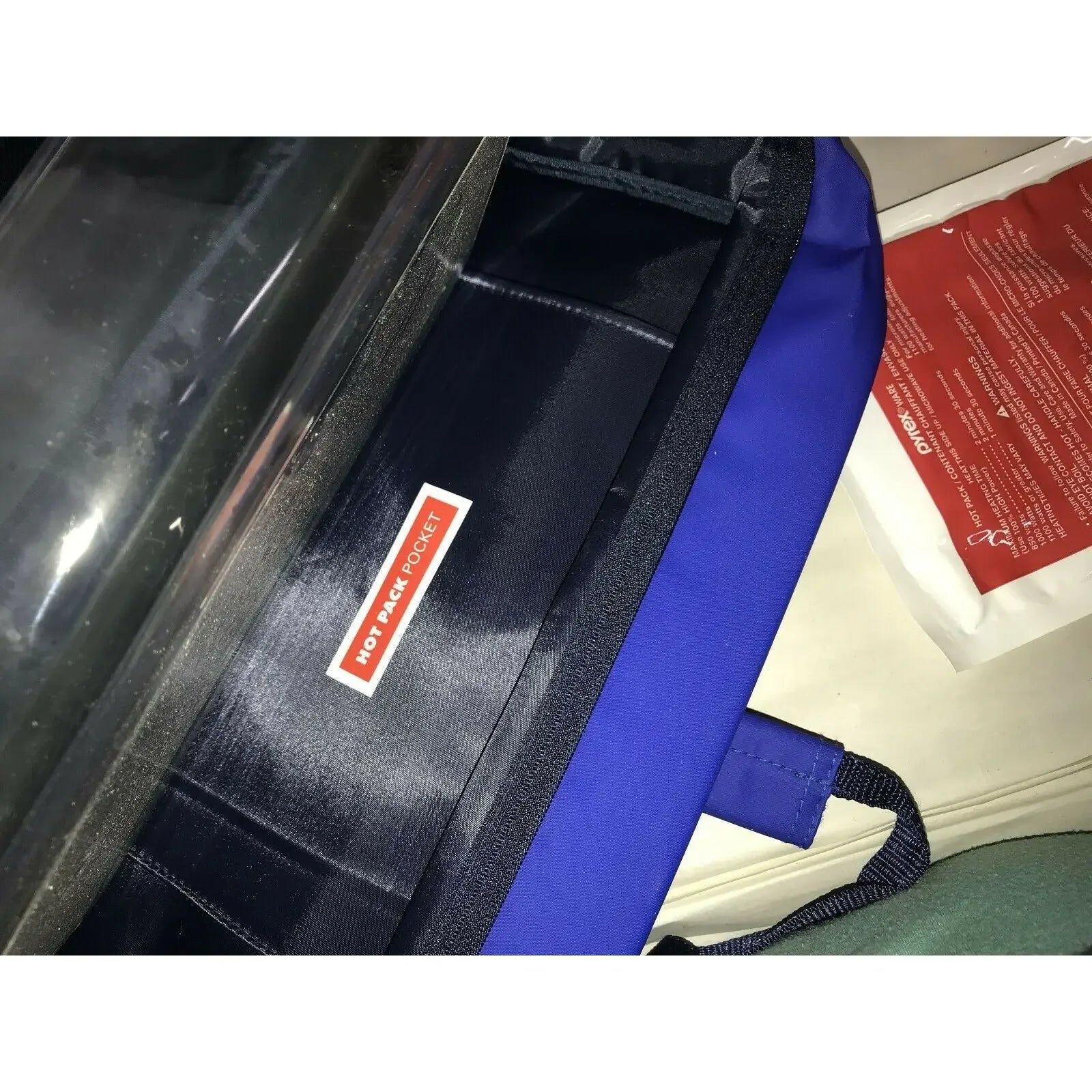 Blue insulated bag with labeled hot pack pocket and visible red hot pack insert