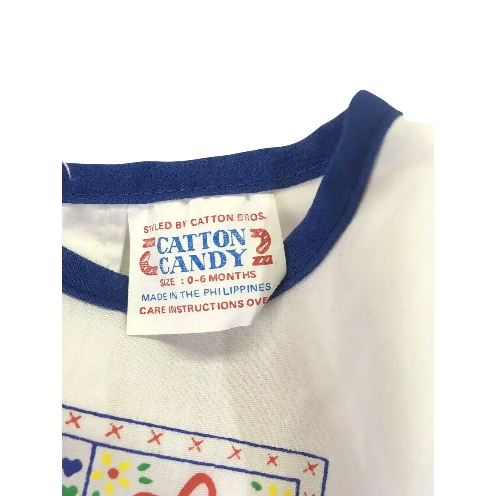 Close-up of a baby clothing tag, blue trim, size 0-6 months, Catton Candy label.