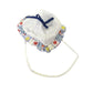 White baby bonnet with colorful patterned trim and blue ribbon on white background
