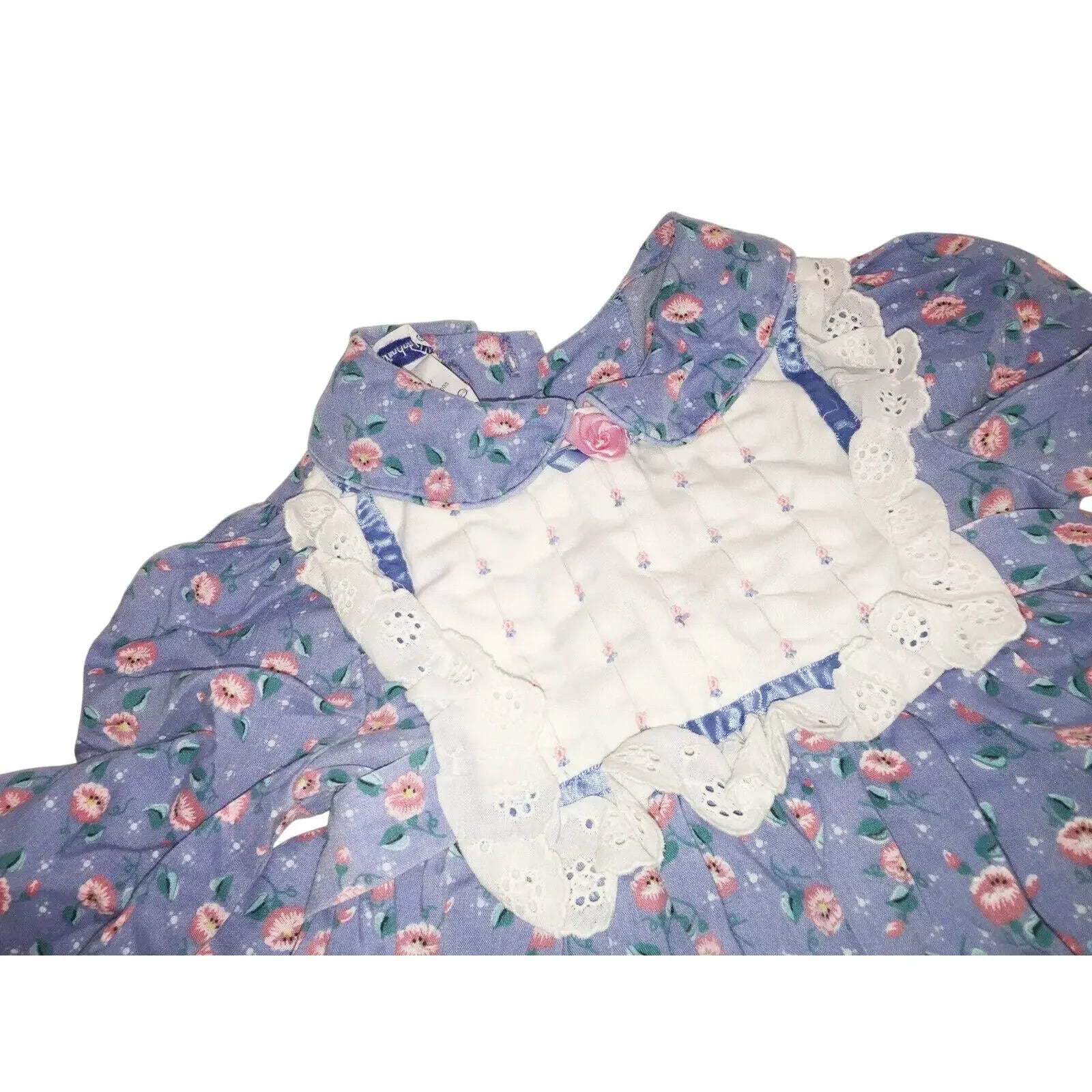 Purple floral dress with lace collar, quilted white bib, and pink rosette accent