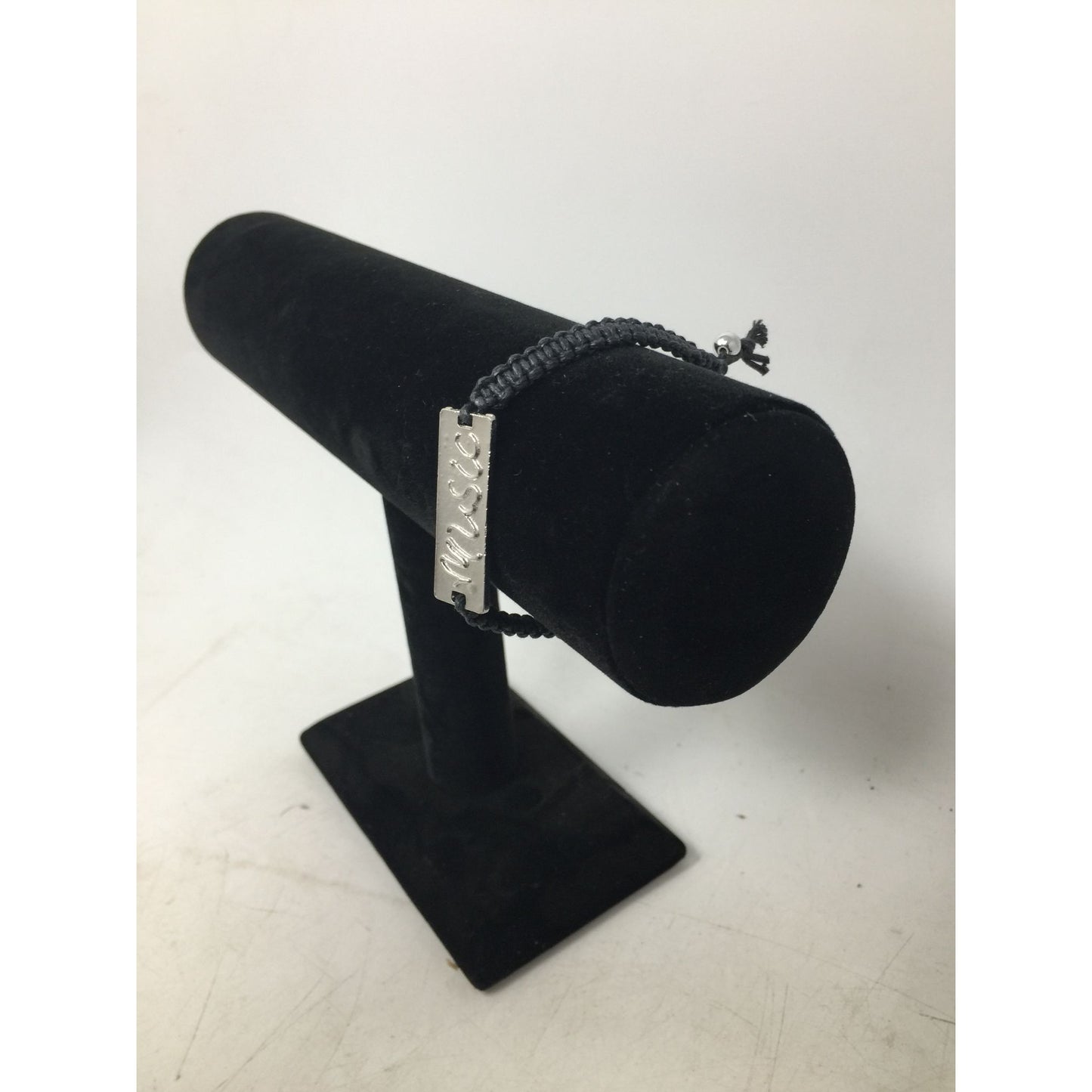 Black Bracelet with Silver Tone Pendant that says ''Music'' in Cursive