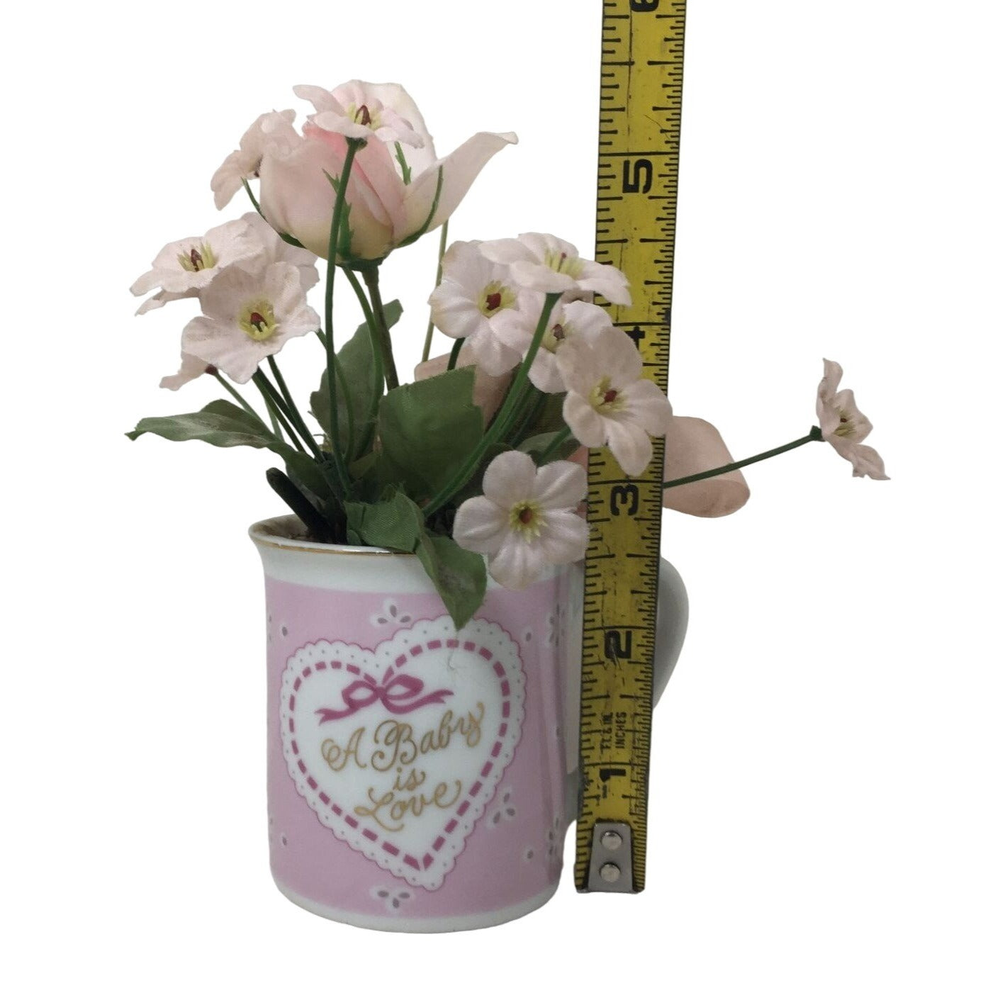 Small Faux Flower Bouquet in Pink Handled Mug that Says "A Baby is Love"