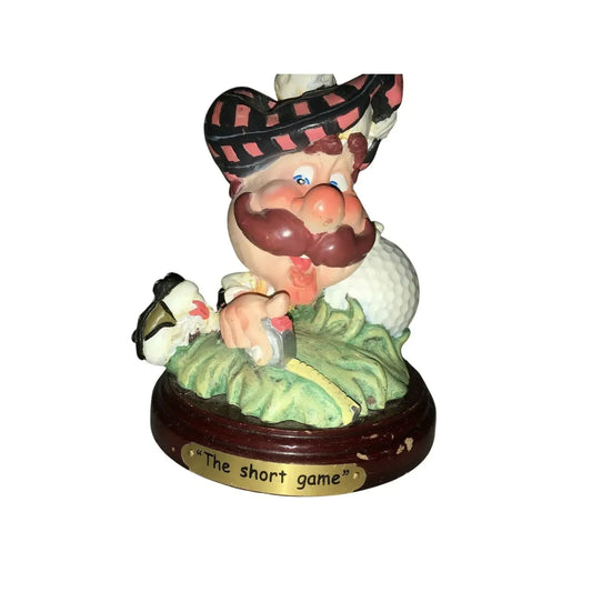 Funny golfer figurine with mustache, golf club, and ball, labeled The short game