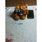 Plush tiger toy with white patches beside a smartphone on a scratched white table, tagged 5294.