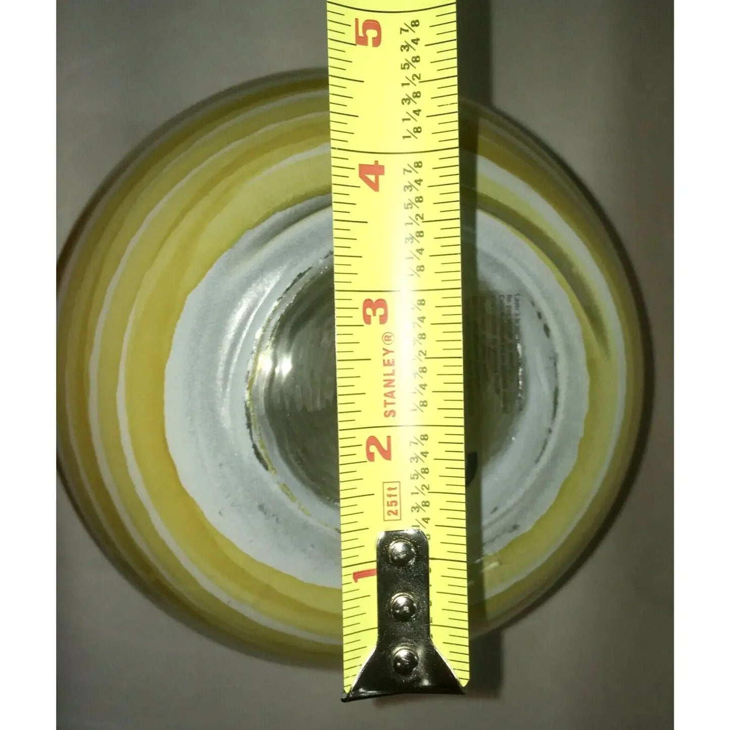 Yellow and white ceramic bowl measured with tape measure for diameter