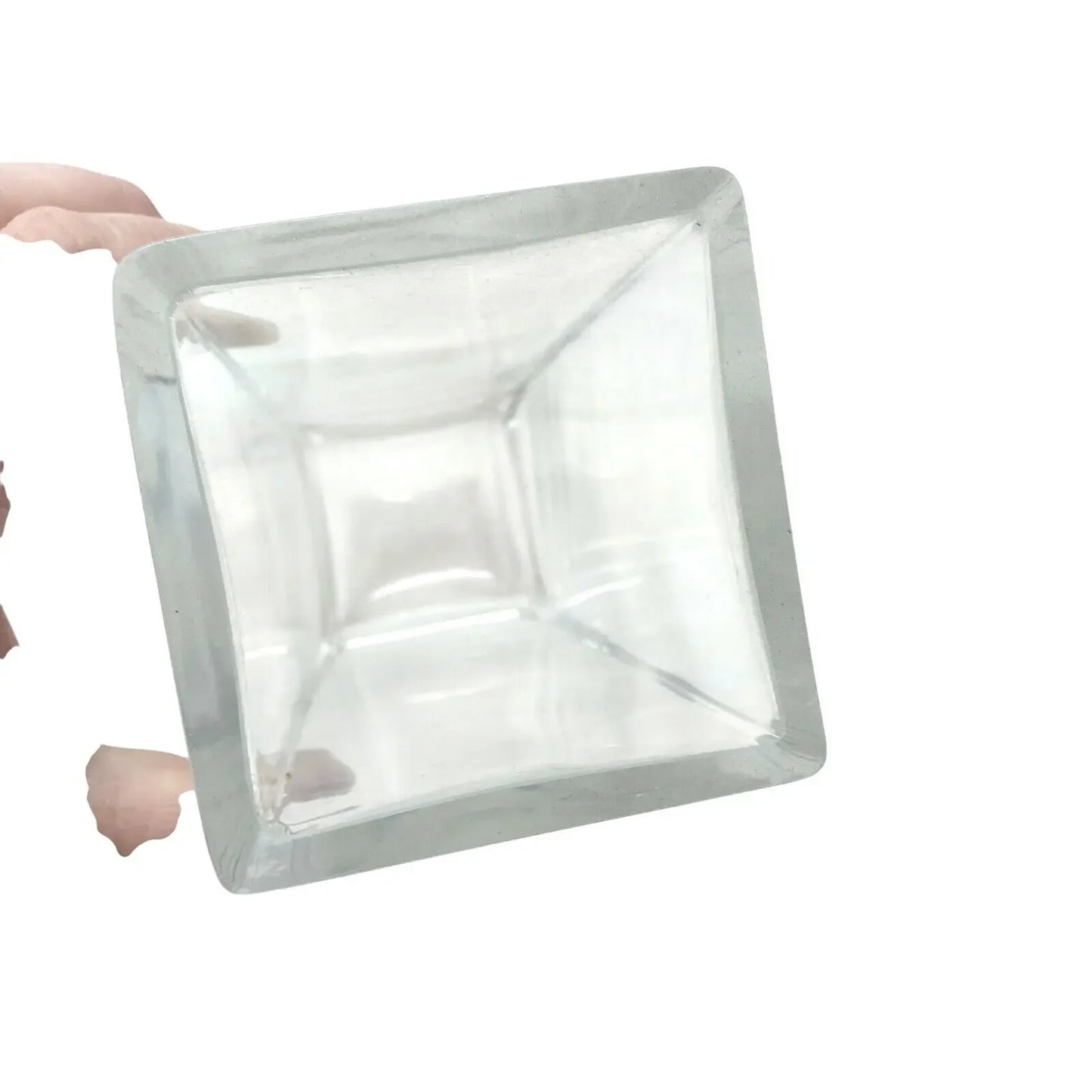 Hand holding a clear square glass container with smooth edges on a white background