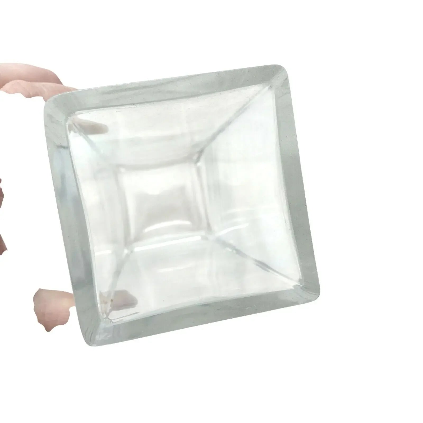 Hand holding a clear square glass container with smooth edges on a white background